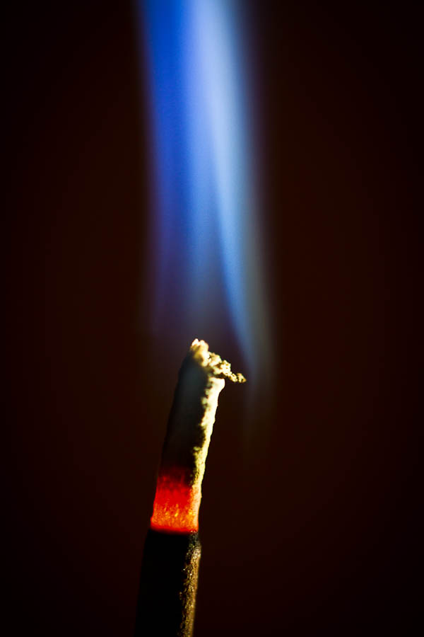 Burning sandalwood incense with blue smoke plume
